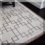 DR02. Brown and cream colored rug with geometric design. Approx. 9'9” x 13'6” 